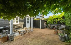 a backyard with a wooden deck with a table and chairs at 3 Bedroom Awesome Home In Hornbæk in Hornbæk +20 photos