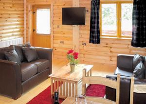 a living room with a couch and a table at Beech Hedge in Coupar Angus