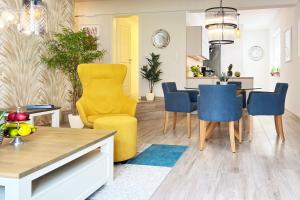 a kitchen and living room with a yellow chair and a table at FeWo Muschelsucher in Wustrow