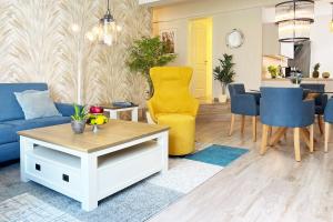 a living room with a blue couch and a table at FeWo Muschelsucher in Wustrow