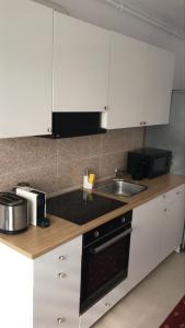 a kitchen with white cabinets and a sink at Piatra Craiului Residence Zărnești in Zărneşti