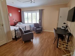a bedroom with a bed and a desk in a room at Hotell Zlafen Bed and Breakfast in Karlskoga