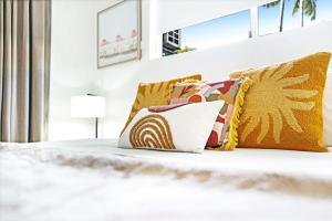 a bed with yellow and white pillows on it at 12 Central Plaza Port Douglas in Port Douglas