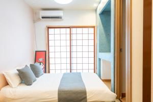 Una cama o camas en una habitación de 关西机场难波梅田直达花園町の夢旅人