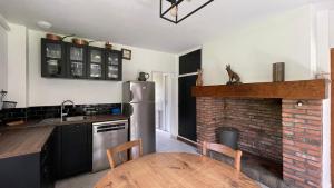 una cucina con tavolo e camino in mattoni di Les Bruyeres, maison proche mer a Hautot-sur-Mer Altre 16 foto