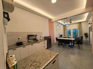 a kitchen and dining room with a table and chairs at Langkawi Simfoni Cassia Suite 04 9pax in Kuah