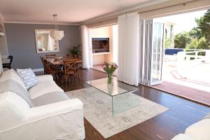 uma sala de estar com um sofá branco e uma mesa de vidro em Seabreeze Luxury Two Bedroom Self Catering Penthouse em Simonʼs Town