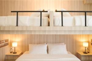 a bedroom with two bunk beds with white pillows at Potji's private apartment in Bang Su