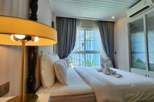 a bedroom with a large bed with a window at Luxury 1 Bedroom condo close to Beach - G411 in Na Jomtien +21 photos