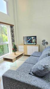 a living room with two beds and a flat screen tv at GRAND VIEW BAGUIO CONDO TRANSIENT by DEI GRATIA in Baguio +23 photos