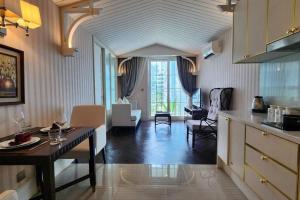 a kitchen and living room with a table and chairs at Luxury 1 Bedroom condo close to Beach - G411 in Na Jomtien