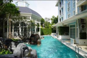 a swimming pool in front of a building at Luxury 1 Bedroom condo close to Beach - G411 in Na Jomtien