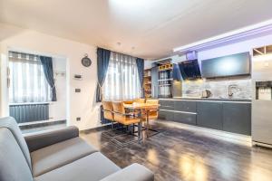 a living room with a table and a kitchen at Log In Rooms in Zagreb