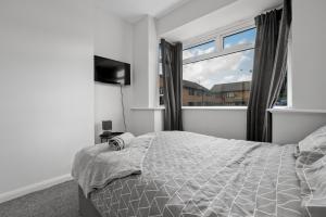 ein Schlafzimmer mit einem Bett und einem großen Fenster in der Unterkunft The Castle - Grimsby/Cleethorpes perfect for Contractors in Grimsby