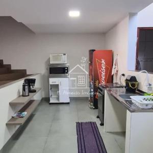 una cocina con encimeras y electrodomésticos blancos en Sobrado I Guaiapó, en Maringá