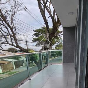un balcón de un edificio con un árbol en Sobrado I Guaiapó, en Maringá