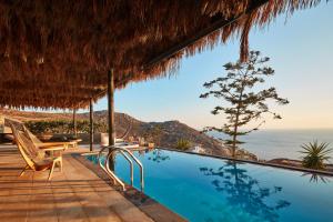 a resort pool with a view of the ocean at Myconian Utopia Relais & Chateaux in Elia Beach