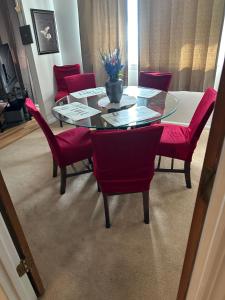 a dining room with a glass table and red chairs at Serenity Retreat near Camp Lejeune & Beaches in Jacksonville