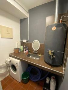 Una pequeña cocina con fregadero y lavadora. en SOHO Chacras de Coria Casa Completa, en Chacras de Coria