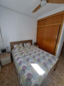 sypialnia z łóżkiem i drewnianą szafką w obiekcie orihuela costa - torrevieja w mieście Orihuela