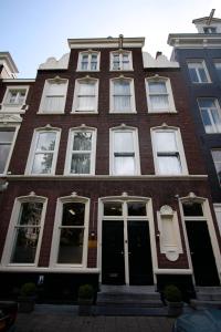 a red brick building with white windows and a door at Hotel Hortus in Amsterdam