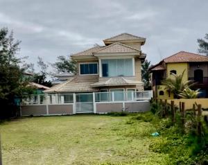 a large house with a yard in front of it at Casa refúgio de paz in Cabo Frio