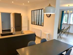 a kitchen with a sink and a table with chairs at Maison de charme Suzanne in Suzanne +14 photos