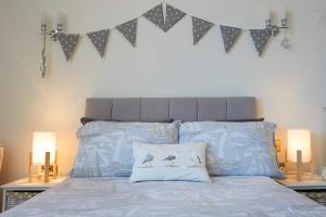 una cama con dos almohadas y un cabecero con banderas en Apartment 17, The Moorings - Stunning sea views, en Filey