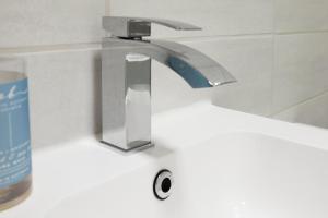 lavabo con grifo en el baño en Apartment 17, The Moorings - Stunning sea views, en Filey