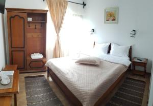 a bedroom with a bed and a large window at Casa Irina in Durau