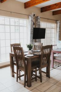 a dining room table with two chairs and a television at Hadens Guesthouse in Nelspruit
