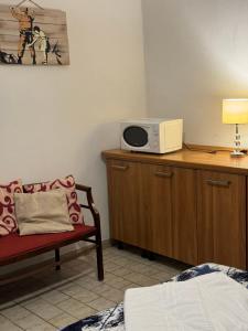 a room with a microwave on a desk with a chair at The Wolf House Greysclass in Venice