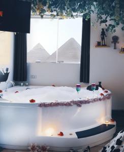 a bath tub with two wine glasses in front of a window at Pyramids ICON 4 & 5 in Cairo