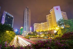 un perfil urbano por la noche con edificios y coches en Yo Yo Apartment Zheng Jia Dong Fang Branch, en Guangzhou