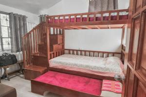 una camera con 2 letti a castello e un tappeto rosa di TwinkleVille Christmas-Themed Cottage a Kayagan