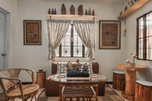 a living room with a table and chairs and a window at TwinkleVille Christmas-Themed Cottage in Kayagan