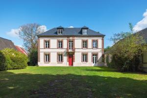 BaromesnilにあるLa Baronnerie Normande - Piscine et jacuzziの芝生の上にある赤いドアの大きな家