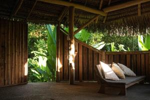 a porch with a bench on a wooden deck at Haliksai - Bungalows, Glamping and Retreatcenter in Las Lomas