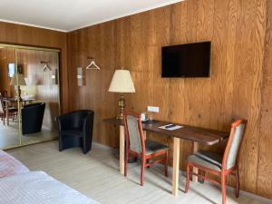 a hotel room with a desk and a television on a wall at Motel in Teterow