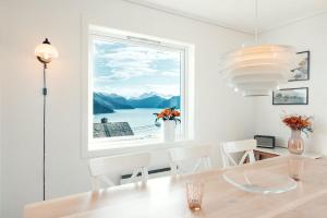 a dining room with a window and a table and chairs at Fjord Panorama in Stranda