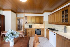 a kitchen with wooden cabinets and a table with a vase at Apartment Panorama & Bella Vista in Bohinjska Bela +17 photos