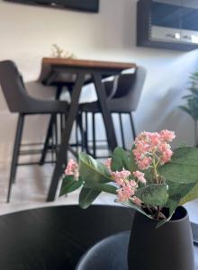a vase with pink flowers on a table with chairs at Stilvoll-Fewo mit Garten in Spremberg