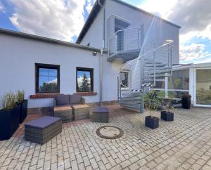 a white house with a patio with a staircase at Stilvoll-Fewo mit Garten in Spremberg