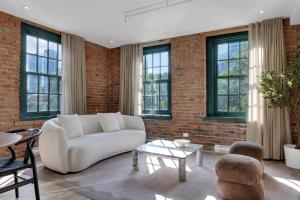 a living room with a white couch and a brick wall at The Mercer Boutique Hotel in Montreal +157 photos