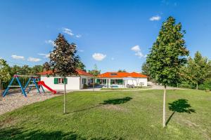 een tuin met een speeltuin en een huis bij Villa Great Escape in Šumet