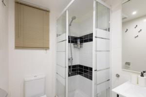 een witte badkamer met douche en toilet bij Bonito piso cerca de park guell in Barcelona +15 foto's