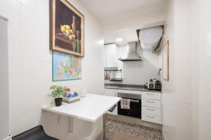 een keuken met witte muren en een wit aanrecht bij Bonito piso cerca de park guell in Barcelona