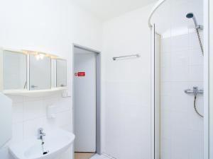 biała łazienka z umywalką i prysznicem w obiekcie Hostel BOHEMIA w Pradze