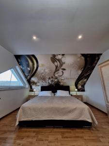 a bedroom with a bed and a wall with paintings at Meduza Wellness Spa s ubytovaním in Hlohovec