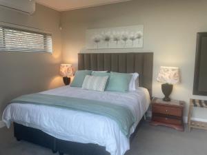 a bedroom with a large bed with two lamps at The View, Apartment, with magnificent sea view in Hermanus